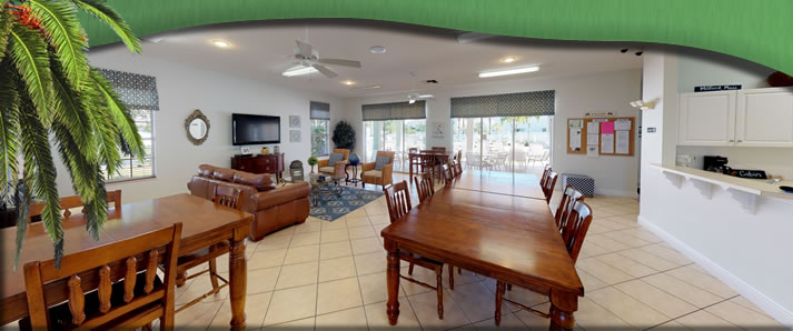 Forest Lake clubhouse meeting room with wooden dining tables, a sitting area and a kitchenette