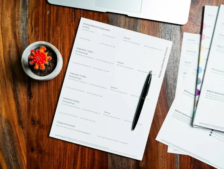 Paper forms and a pen on a wooden desk